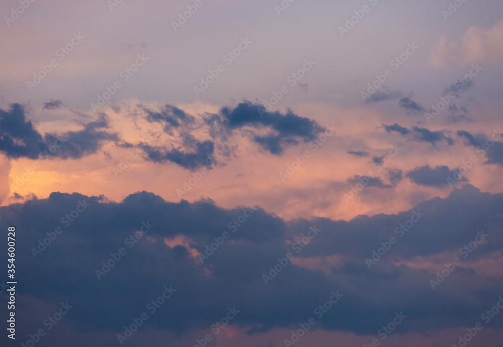 Beautiful dramatic gray and white clouds on blue sky, variety of shapes, silhouettes and shades at sunset time Beautiful dramatic gray and white clouds on blue sky, variety of shapes, silhouettes and shades at sunset time