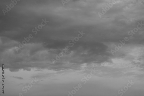 Beautiful dramatic gray and white clouds on blue sky, variety of shapes, silhouettes and shades at sunset time