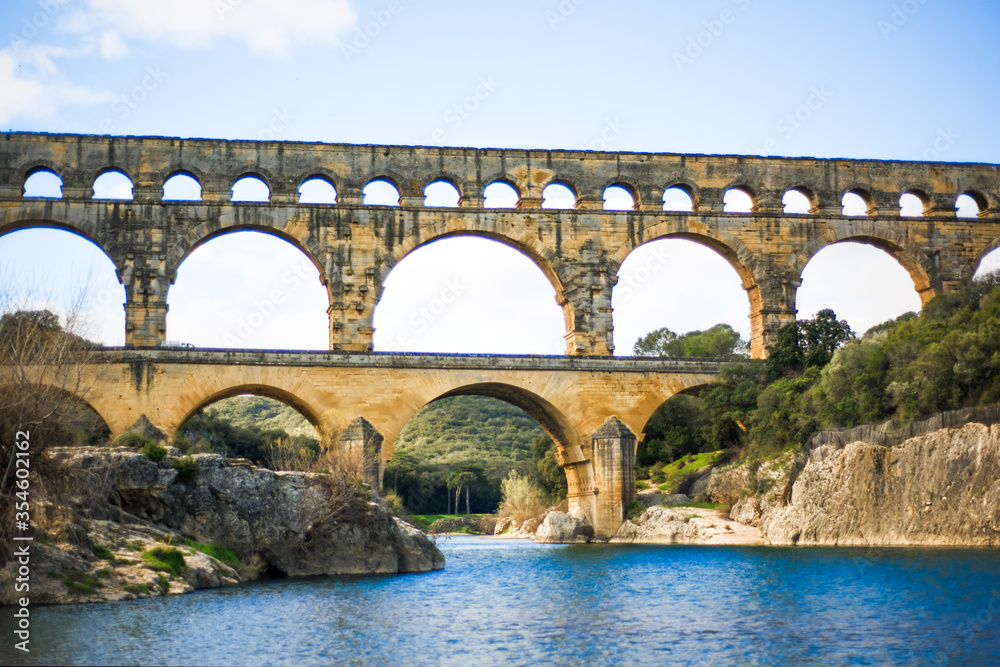 Gardon river and roman aqueduct Pont du Gard, Unesco World Heritage site. Located near Nimes, Languedoc, France, Europe. Big stone roman arch. Travel tourism destination in Provence
