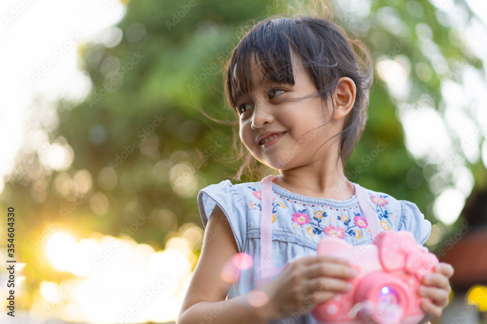 Beautiful 4 years old asian little girl is smiling with happy moment while she is playing bubbles outdoor. - obrazy, fototapety, plakaty 