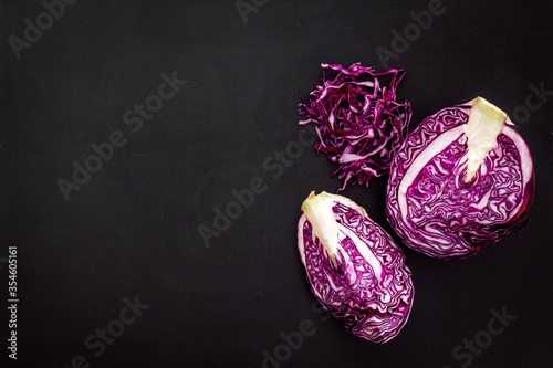 Photo Red cabbage - cut head and sliced - on black desk from above copy space