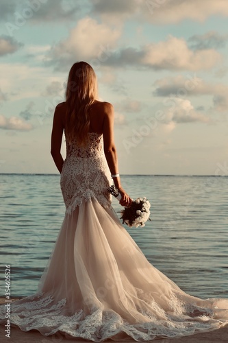bride with bouquet flowers on the beach © Gnevkovska