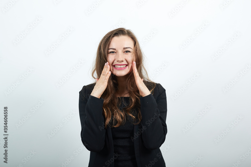 Touching her cheeks with hand and smiling, smooth, flawless skin, young attractive woman brunette in a black t-shirt, sweater on white background Touching her cheeks with hand and smiling, smooth, flawless skin, young attractive woman brunette in a black t-shirt, sweater on white background
