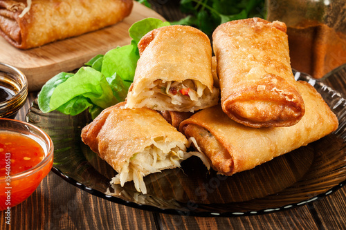 Foto Spring rolls with chicken and vegetables served with sweet chili sauce or soy sa