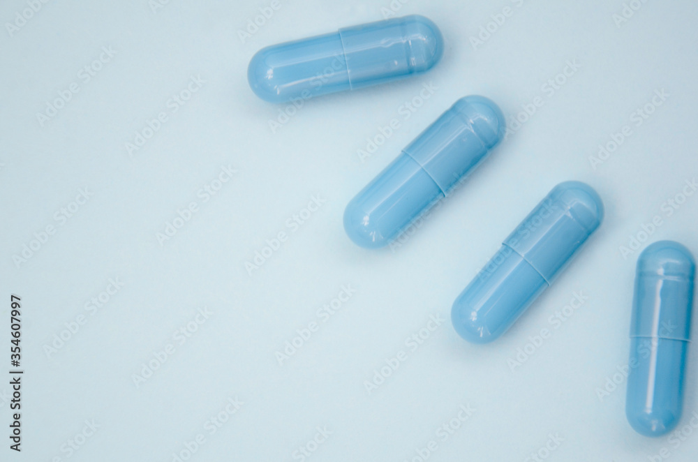 Blue capsules on a blue background. Flatlay, layout, copyspace. Blue capsules on a blue background. Flatlay, layout, copyspace.