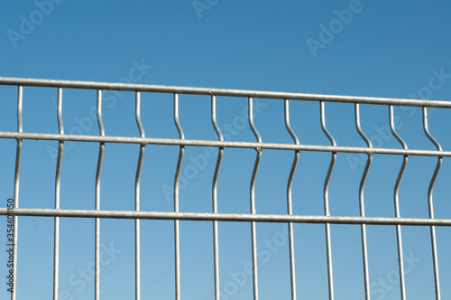 a simple zinc plated fence in sunlight