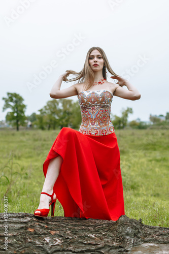 Model in a red dress in nature.