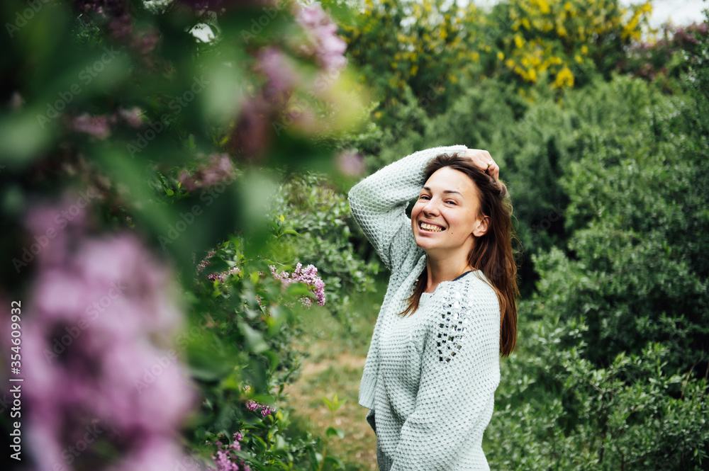 Outdoor fashion photo of beautiful young woman surrounded by flowers. Spring blossom Outdoor fashion photo of beautiful young woman surrounded by flowers. Spring blossom
