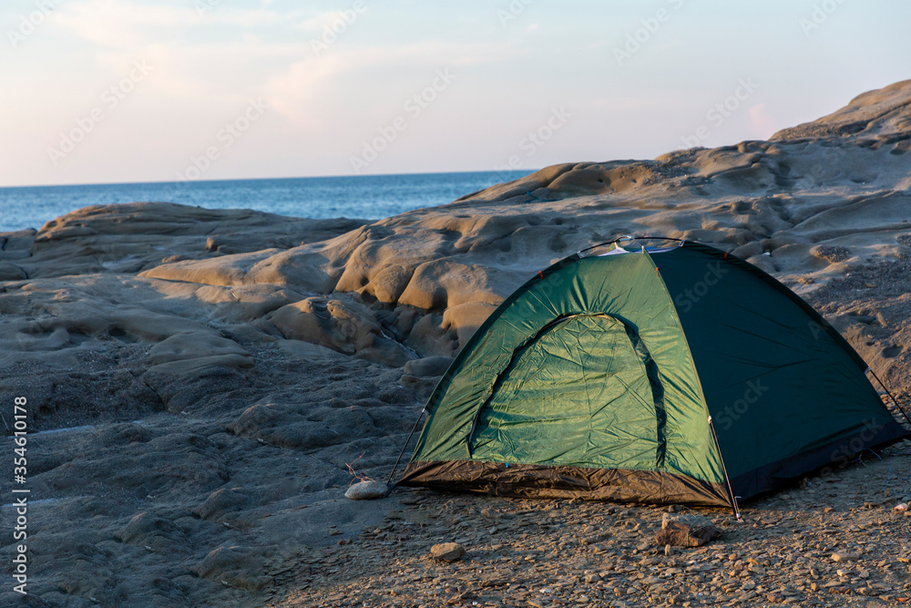 Camping on the cliffs by the sea at sunset