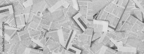Long horizontal banner with lots of old newspapers on horizontal surface. Background texture, top view, blurred. Concept for news and information - could be used for web design or advertisement
