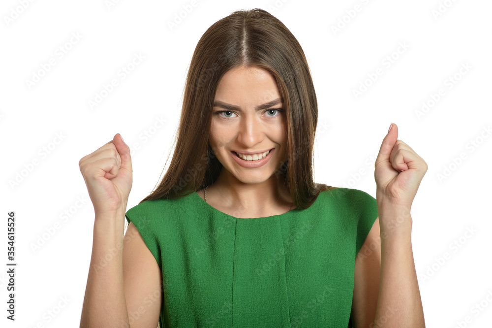 Beautiful woman in green dress gesturing winner sign on white background