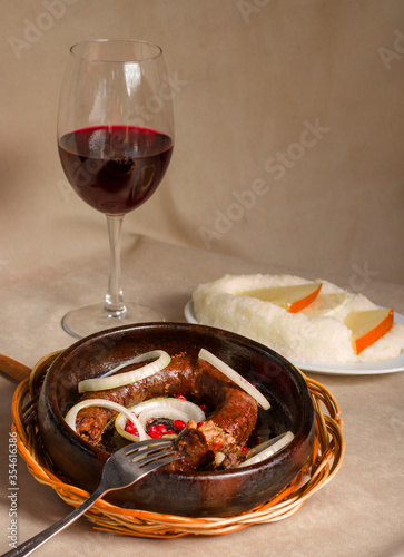 Georgian traditional food and cuisine Kupati and red wine, ghomi and cheese. photo