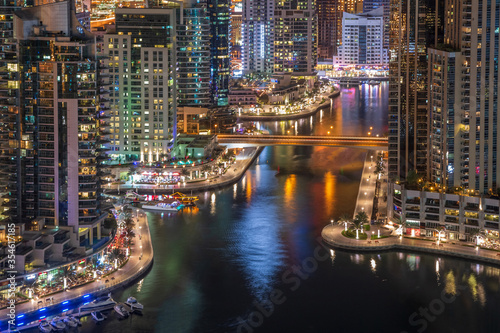 Dubai Marina promenade and water canal at night. Aerial view of Dubai skyscrapers. © Monica