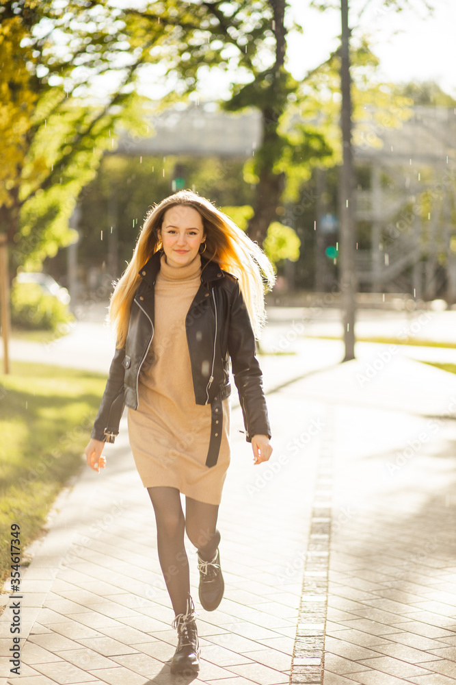 Happy young woman turns around and runs at camera on rainy and sunny day Happy young woman turns around and runs at camera on rainy and sunny day