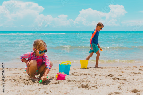 boy and girl play with sand on beach vacation
