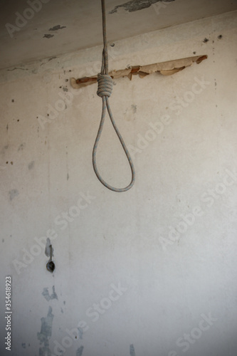 Deadly loop hanging from the ceiling in abandoned apartment. Concept of suicide, despair