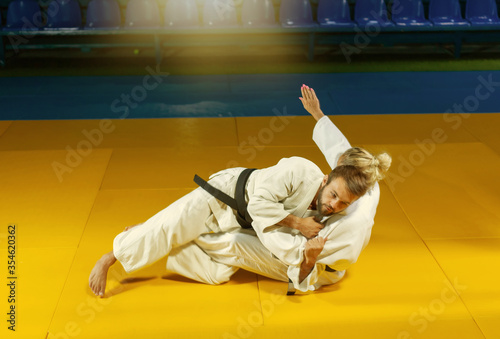 Martial arts. Sparing Portners. Sport man and woman in white kimono train judo throws and captures in the sports hall