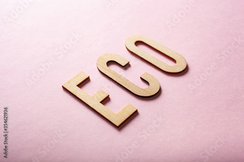 eco word text wooden letters on pink background