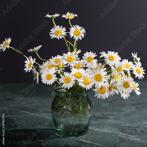 bouquet of wildflowers in a vase stands on the old marble table