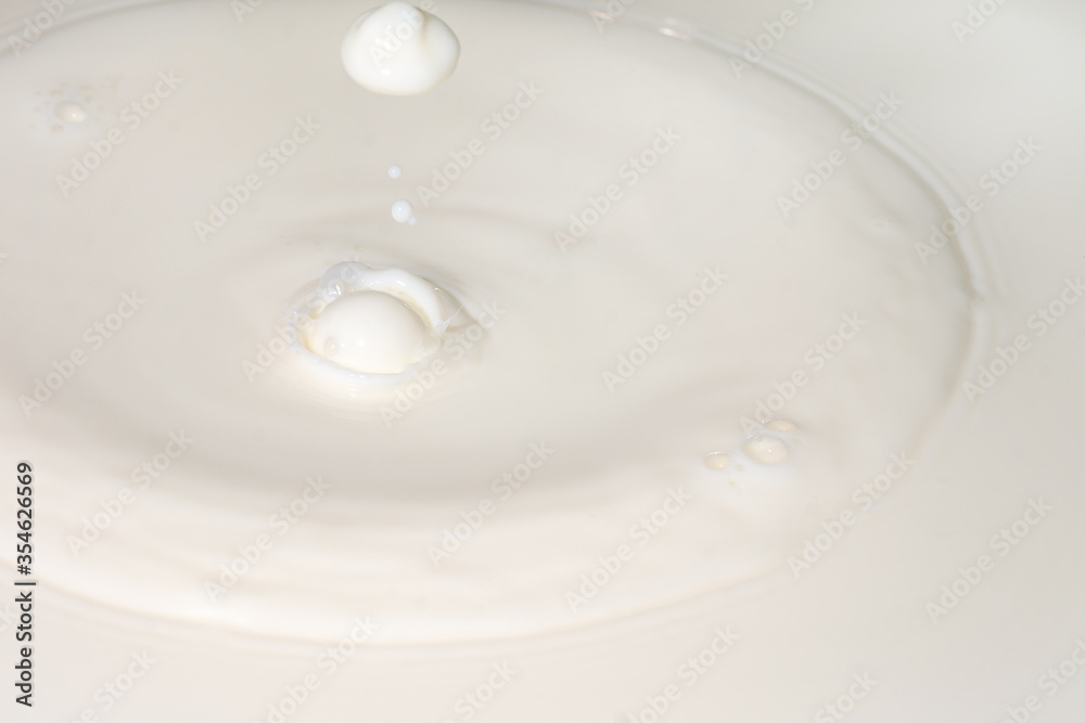 Drops of liquid milk pouring down or white drops with ripples Drops of liquid milk pouring down or white drops with ripples