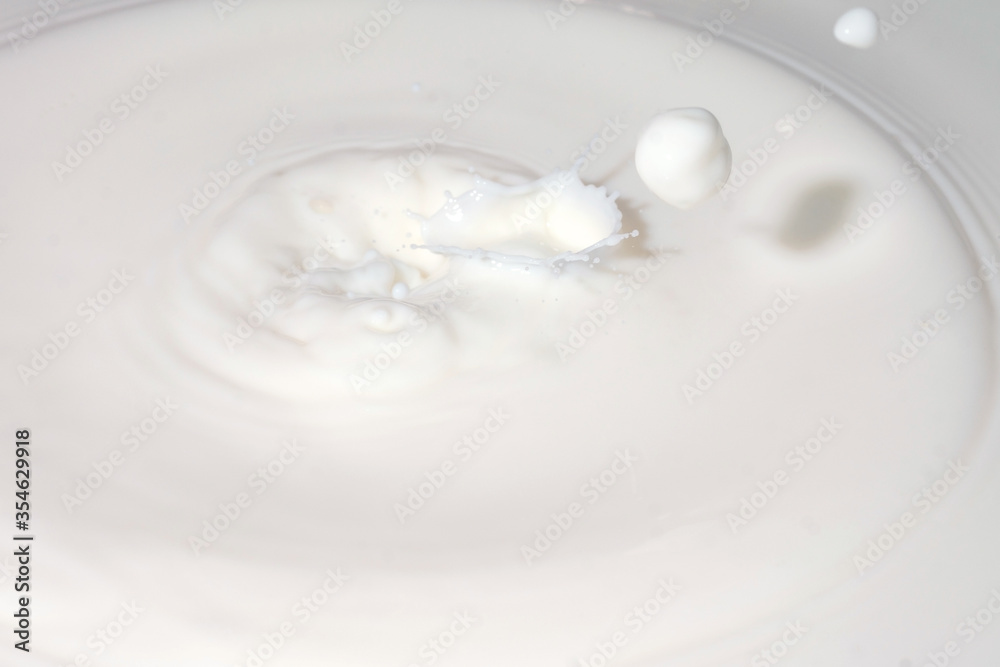 Drops of liquid milk pouring down or white drops with ripples Drops of liquid milk pouring down or white drops with ripples
