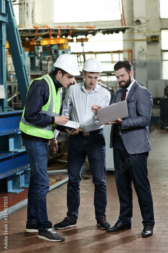 Wallpaper Mural Portrait of a 3 men in a airplane manufactory. Two company managers and one factory worker deciding future plans. Business solution.  Torontodigital.ca