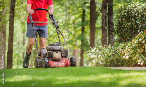 Obraz na plátně Mowing grass with a gas powered lawn mower