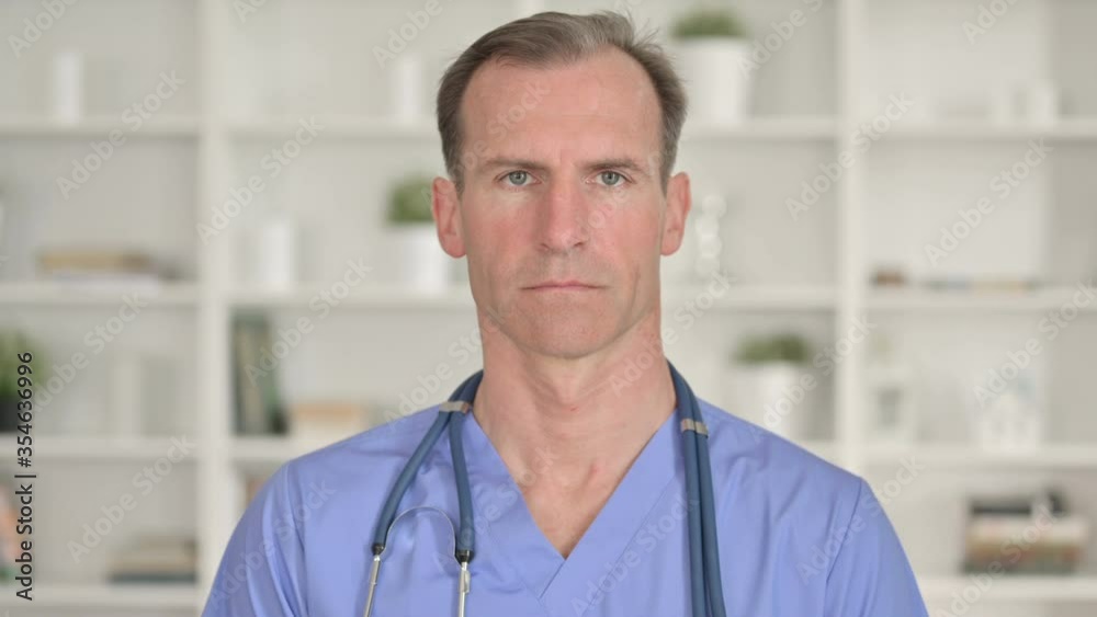 Portrait of Serious Middle Aged Doctor looking at Camera Portrait of Serious Middle Aged Doctor looking at Camera