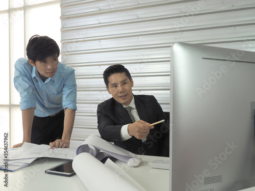 Asian businessman and architect or engineer are discussing work together in office.Man pointing at screen.