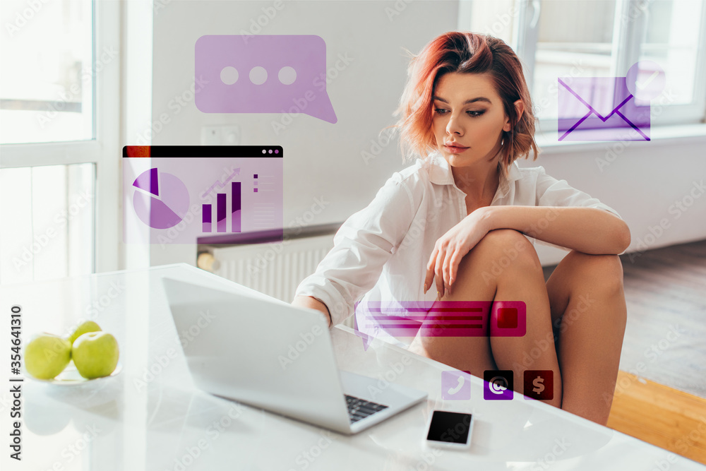 Obraz premium beautiful woman with headphones using laptop on kitchen with apples and smartphone during quarantine with business charts