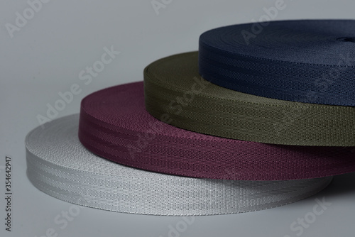 rolls of textile tape on gray background. color tape production.