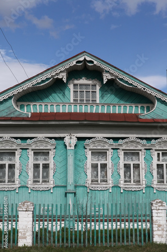 Old rural traditional national wooden house with vintage ornamental carved windows, frames in Myt village, Ivanovo region, Russia. Russian folk style in architecture. Ancient building facade. Landmark photo