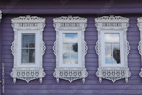 Richly decorated ornamental carved windows, frames on vintage wooden rural house in Palekh village, Ivanovo region, Russia. Russian traditional national folk style in wooden architecture. Countryside photo