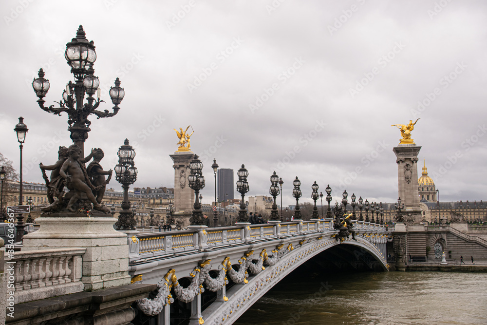Photo of the Alexander III bridge in Paris during a cloudy day