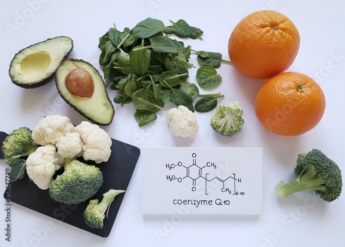 Healthy food sources of CoQ10 with structural chemical formula of Coenzyme Q10. Antioxidant properties; helps generate energy in cells. Assortment of fresh fruits and vegetables high in CoQ10.
