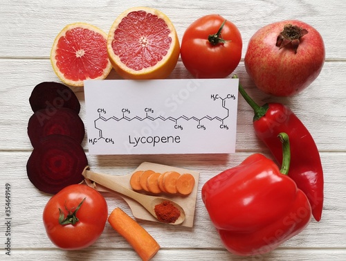 Foods rich in lycopene with structural chemical formula of lycopene molecule. Natural sources of lycopene: tomato, grapefruit, pomegranate, red bell pepper, beetroot, chili powder and carrot.