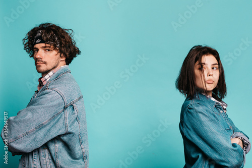 Billede på lærred Separated anger displeased young couple isolated over blue background