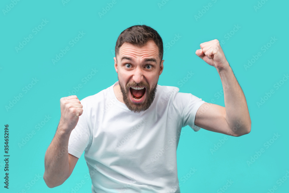 Young bearded man betting online at bookmaker's website Young bearded man betting online at bookmaker's website
