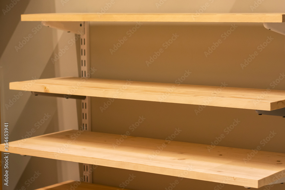 Wooden shelves on the wall. Rack of empty wooden shelves. Shelves for storage. Wooden shelves on the wall. Rack of empty wooden shelves. Shelves for storage.