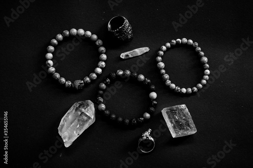 men bracelets, stones and rings in black background