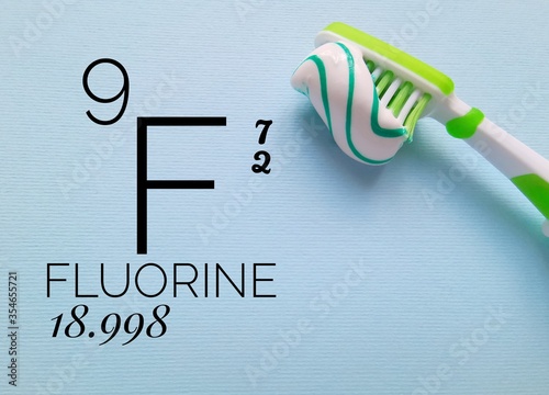 Fluorine is a chemical element of the periodic table with the symbol F and atomic number 9. The symbol F with atomic data and a brush with fluoride toothpaste. photo