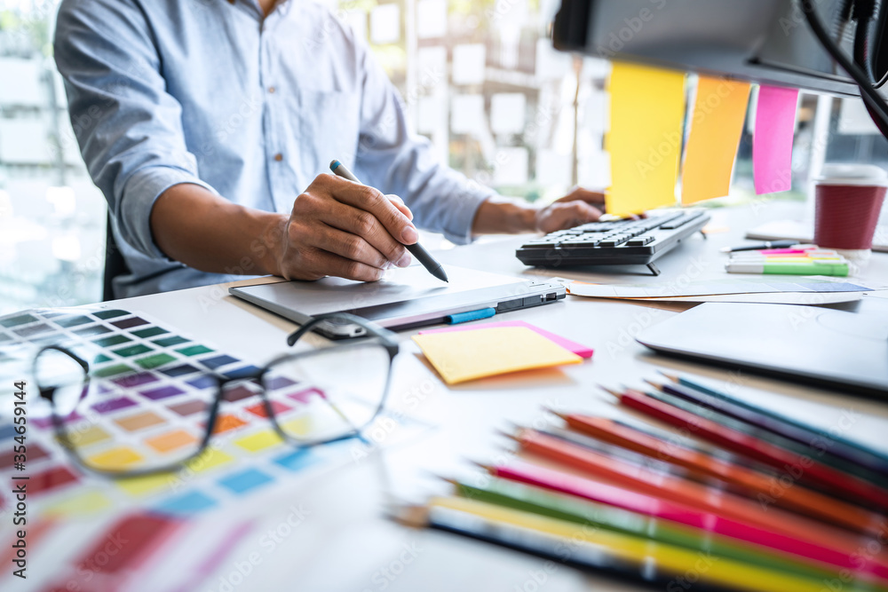 custom made wallpaper toronto digitalTwo colleague creative graphic designer working on color selection and color swatches, drawing on graphics tablet at workplace with work tools and accessories