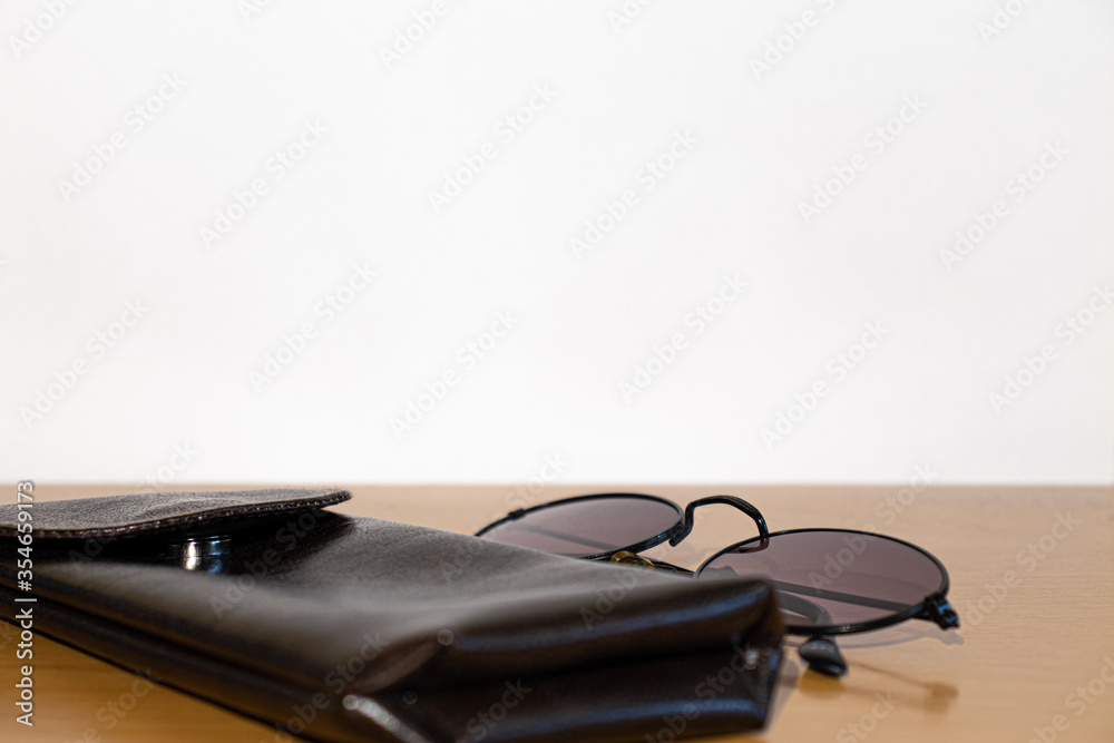 Glasses and brown case on a wooden table Glasses and brown case on a wooden table