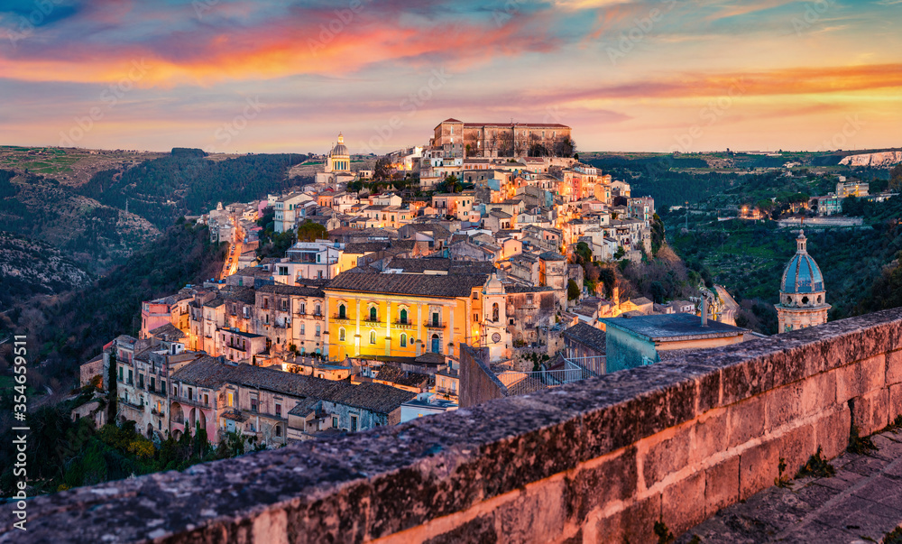 Captivating summer cityscape of Ragusa town with Palazzo Cosentini and Duomo di San Giorgio church on background. Colorful sunset in Sicily, Italy, Europe. Traveling concept background.