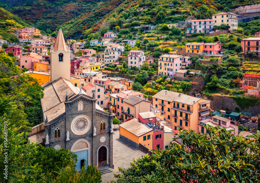 First city of the Cique Terre sequence of hill cities - Riomaggiore with tower of Church of San Giovanni Battista. Wonderful summer scene of Liguria, Italy, Europe. Traveling concept background.