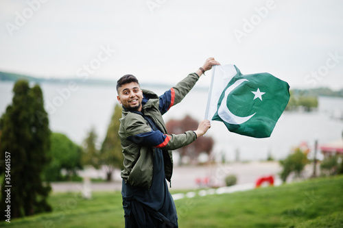 Foto Сonfident pakistani indian muslim arabic boy in grey kameez shalwar suit with Pakistan flag