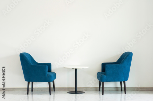 Blue turquoise double armchair with coffee table between armchairs in living room with copy space.