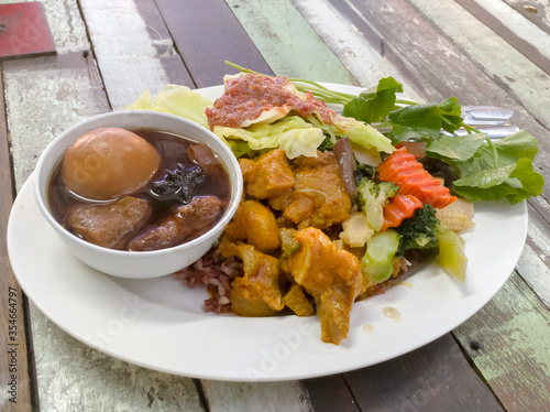 Thai local street food - Pork curry and rice with egg stew and chili paste eat with vegetable