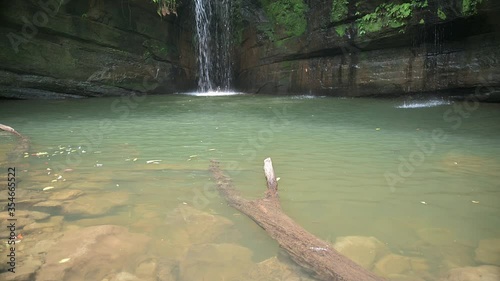 Waterfall cascade down the mossy rock and splashing into the pool. Ferns and moss are growing well on the rock. The rocks are very moist because of the water. Wanggu Waterfall, Pinxi Dist., Taiwan. photo