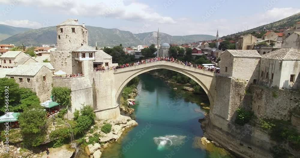 A man does a cannonball jump off the crowded Mostar Bridge in Mostar, Bosnia. A man does a cannonball jump off the crowded Mostar Bridge in Mostar, Bosnia.